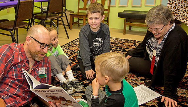 Photo of book being read to children